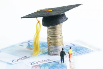 Tocco universitario su pila di monete e banconote da 20 euro